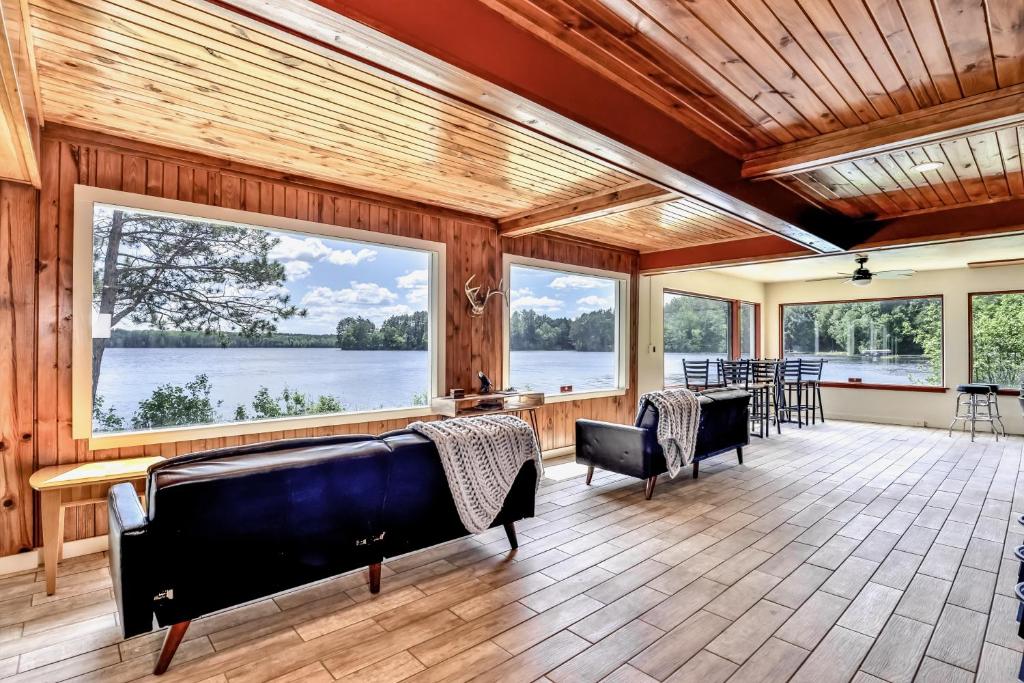 Großes Zimmer mit Fenstern, einem Tisch und Stühlen in der Unterkunft Timber Lodge Retreat in Rhinelander