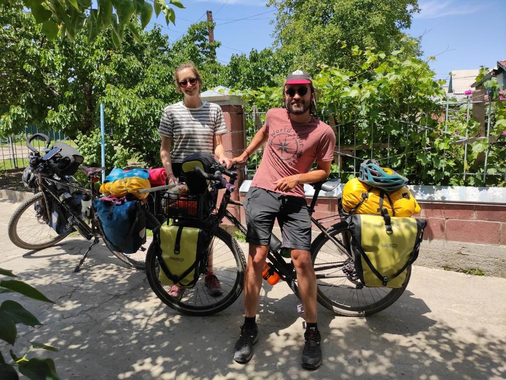 a man and a woman standing next to their bikes at Kurjun in Karakol