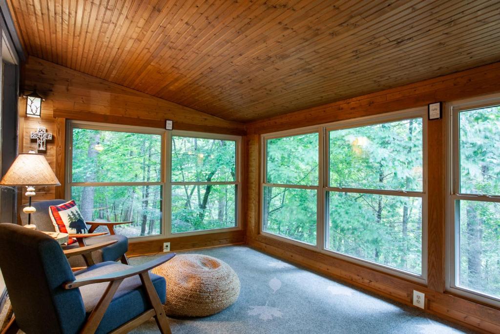 sala de estar con ventanas, mesa y sillas en Quietside Cabin Grill Fire Pit Fireplace, en Walland