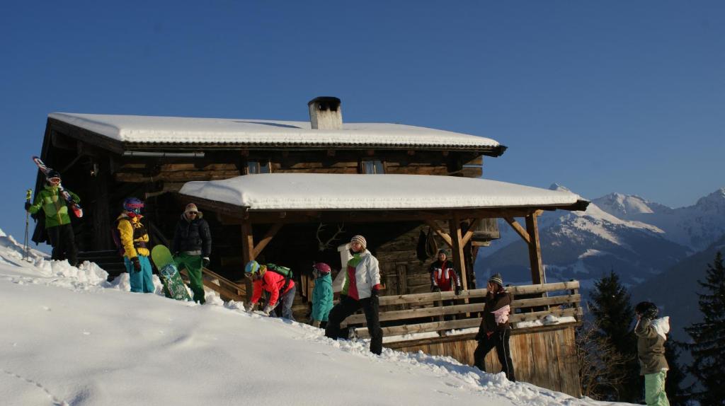 eine Gruppe von Menschen, die vor einer Hütte im Schnee stehen in der Unterkunft Hütte - Ferienhaus Bischoferhütte für 2-10 Personen in Alpbach