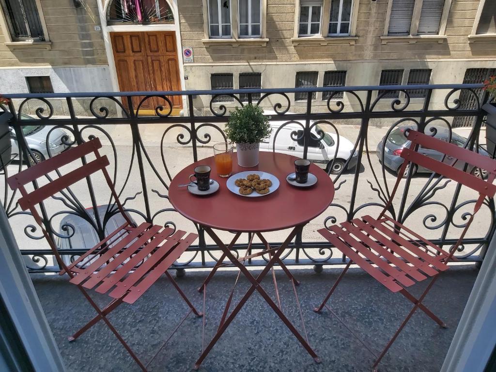 a table with a plate of food on a balcony at Borromini Home in Turin