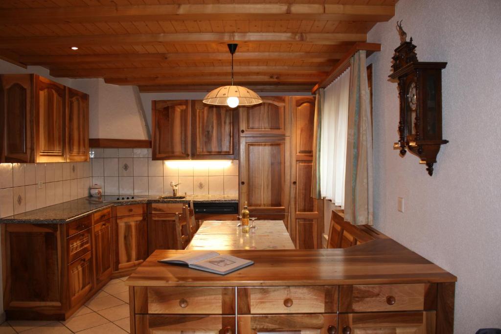ツェルマットにあるChalet Zwächtaの木製のキャビネットと木製の島付きのキッチン
