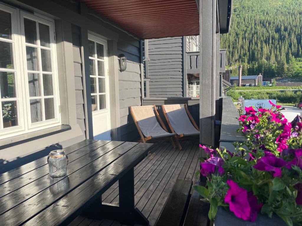 een houten tafel op de veranda van een huis met bloemen bij Tinden in Hemsedal