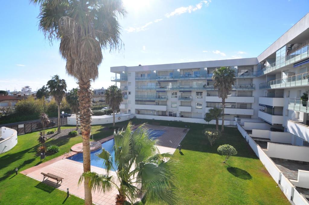 een appartementencomplex met een binnenplaats met palmbomen bij RNET - 221 Porto Marina Roses Costa Brava in Roses