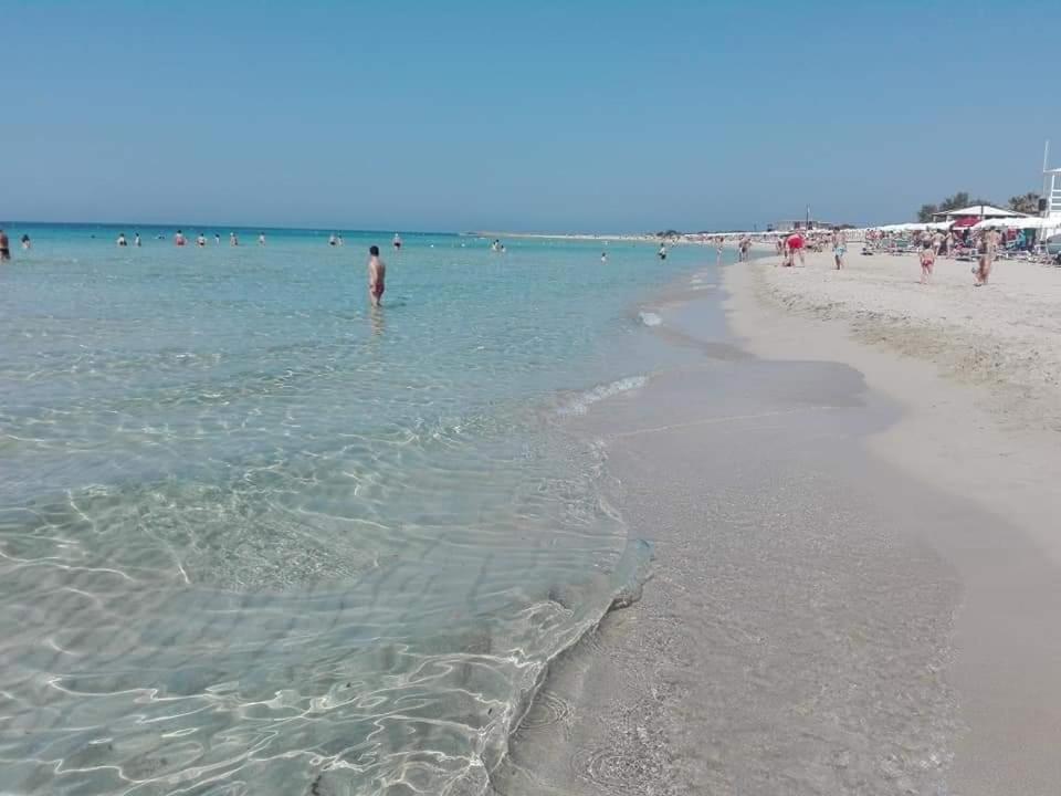 eine Gruppe von Menschen im Wasser am Strand in der Unterkunft Casa 100m dal mare caraibico in Lido Marini