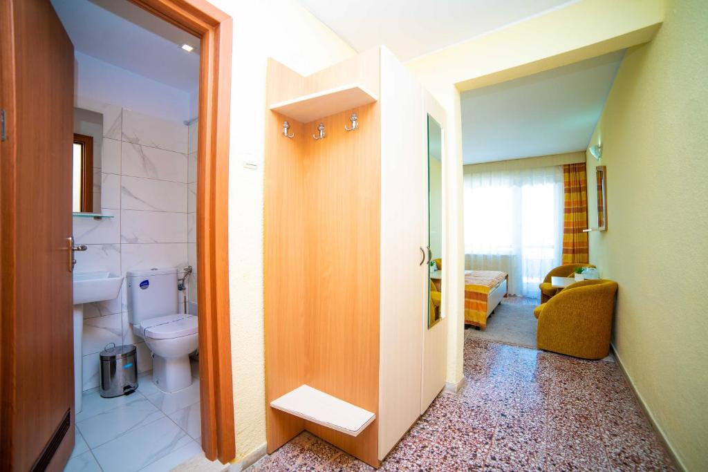 a bathroom with a toilet and a door to a room at Hotel Meteor in Jupiter
