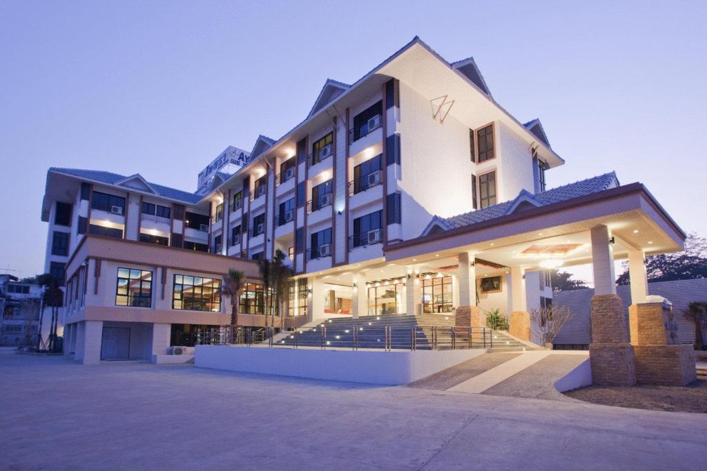 a large building with mountains in the background at Ayara Grand Palace Hotel in Phitsanulok