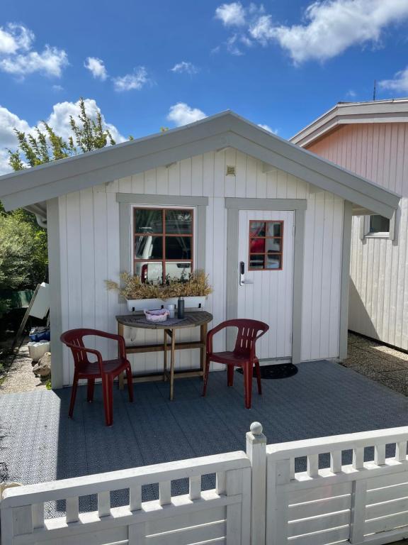 einem Schuppen mit Stühlen und einem Tisch auf einer Terrasse in der Unterkunft Mysigt och centralt in Strömstad