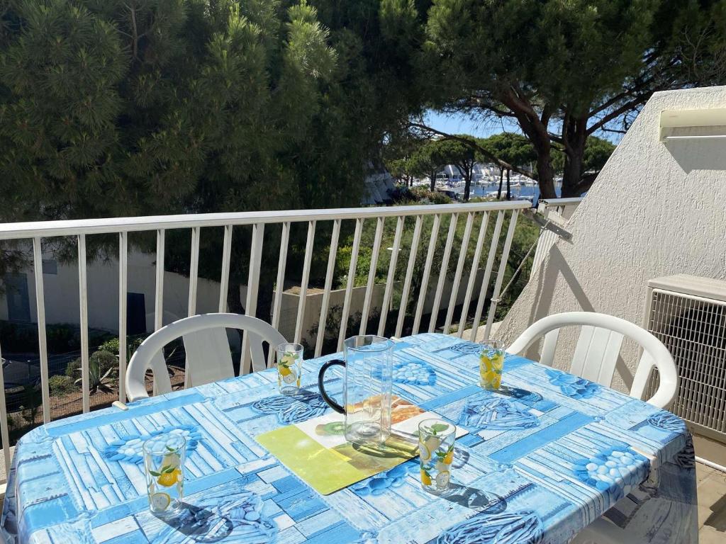 einen Tisch mit einem blauen Tischtuch auf dem Balkon in der Unterkunft Appartement Port Camargue, 1 pièce, 4 personnes - FR-1-250-208 in Le Grau-du-Roi