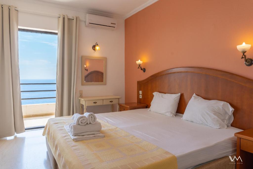 a bedroom with a bed with a towel on it at Arilla Beach Hotel in Perdika