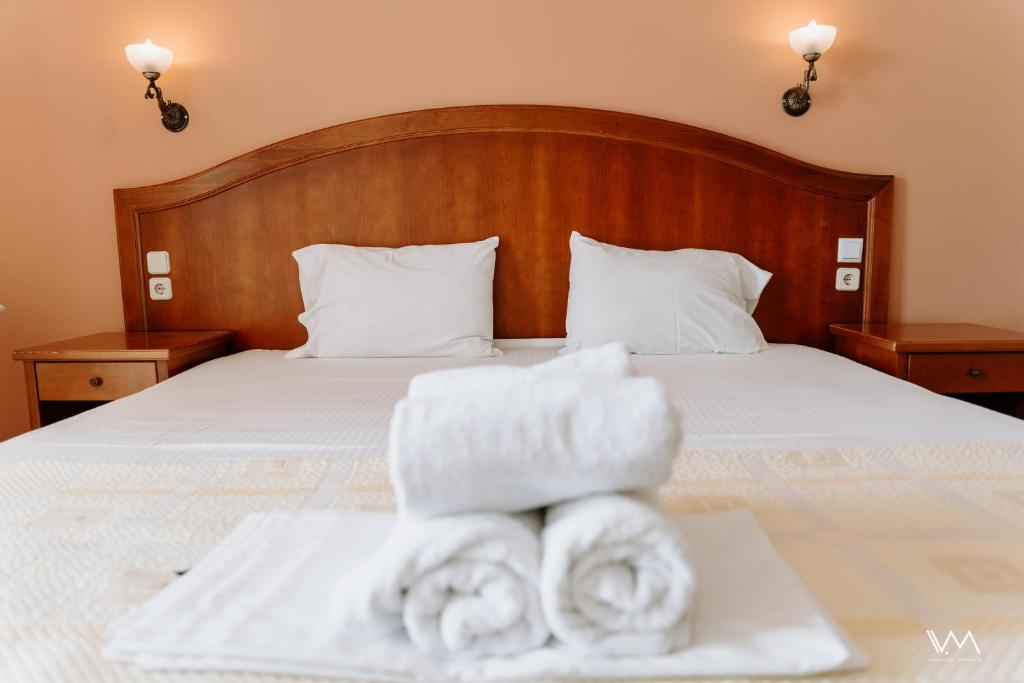 a bedroom with a bed with towels on a tray at Arilla Beach Hotel in Perdika