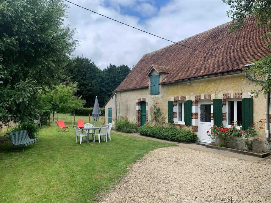 a house with a table and chairs in the yard at Le gîte des Grivots 