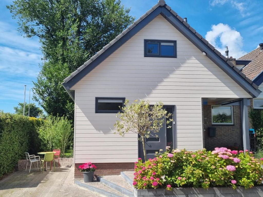 een wit huis met bloemen ervoor bij Logement de Garage in Sneek