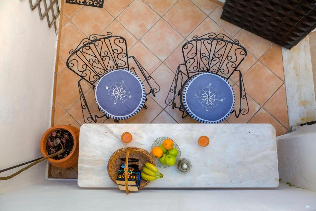 einen Tisch mit zwei Stühlen und Obst darauf in der Unterkunft Campiello Apartments in Korfu-Stadt