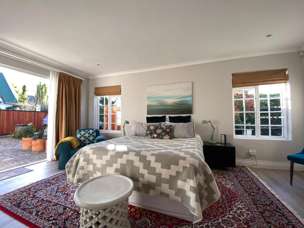 a bedroom with a bed and a rug at Courtyard on Weder in Greyton