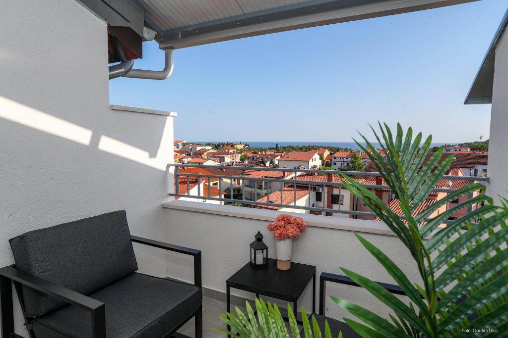 balcón con silla y vistas a la ciudad en Blue sky apartment, en Rovinj