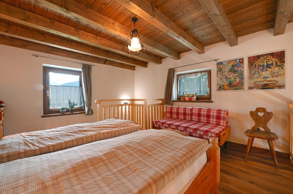 una camera con due letti e una sedia di I girasoli a Sanzeno