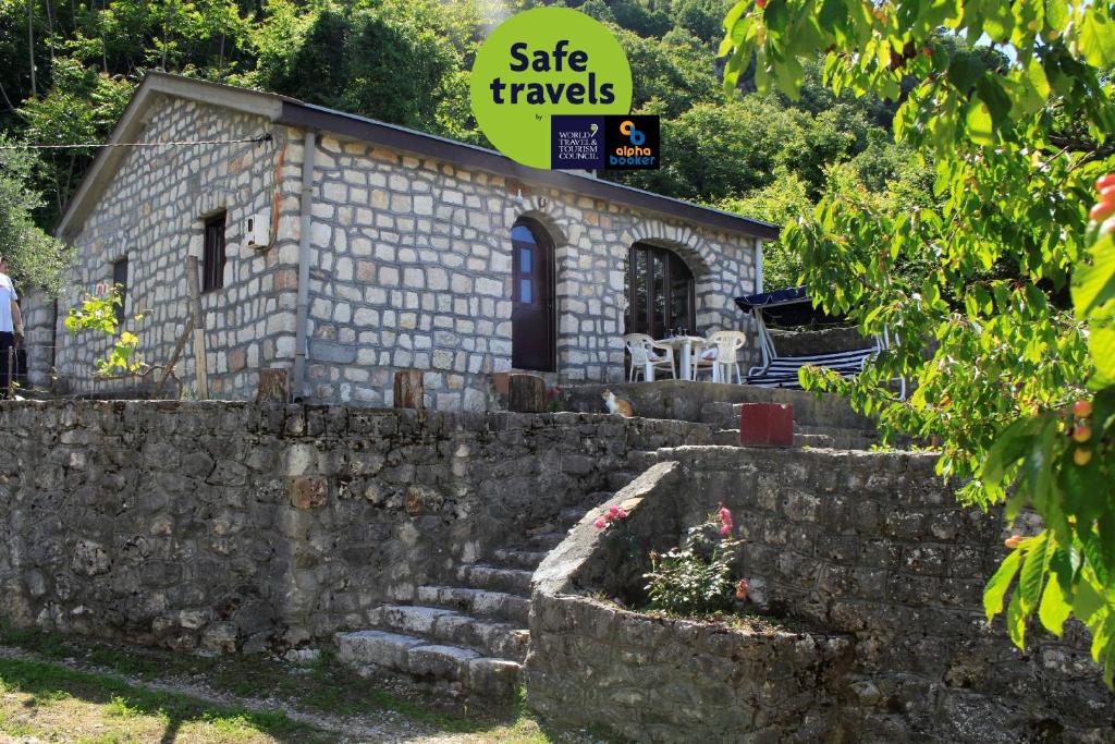 a small stone building with a sign that reads safe travels at Rent House Orahovo in Virpazar