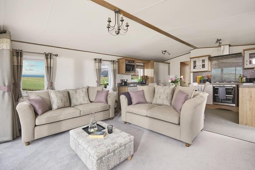 Sala de estar con 2 sofás y mesa en Heywoods caravan holiday home en Morecambe