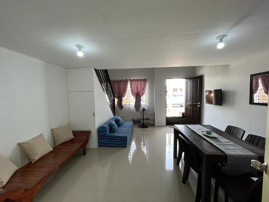 a living room with a table and a dining room at Manzil Jina Laiya House Rental in San Juan