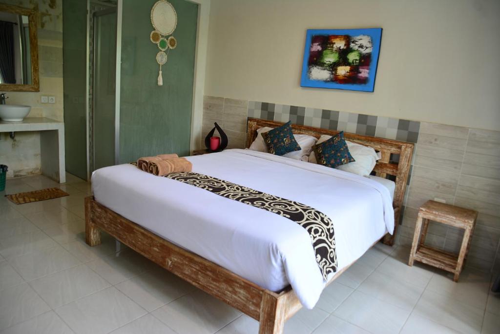 a bedroom with a large bed in a room at Asung Guesthouse in Canggu