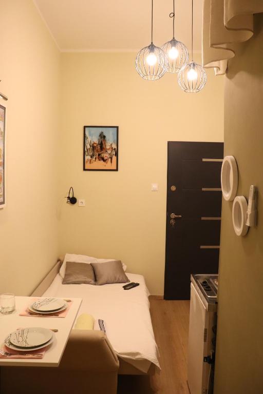 a small room with a bed and a table at Little Zrin Rooms in Zagreb