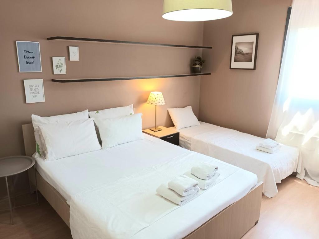 2 camas en una habitación con sábanas blancas y toallas en Crystal Clear - 2 separate bedrooms and PARKING en Komotini