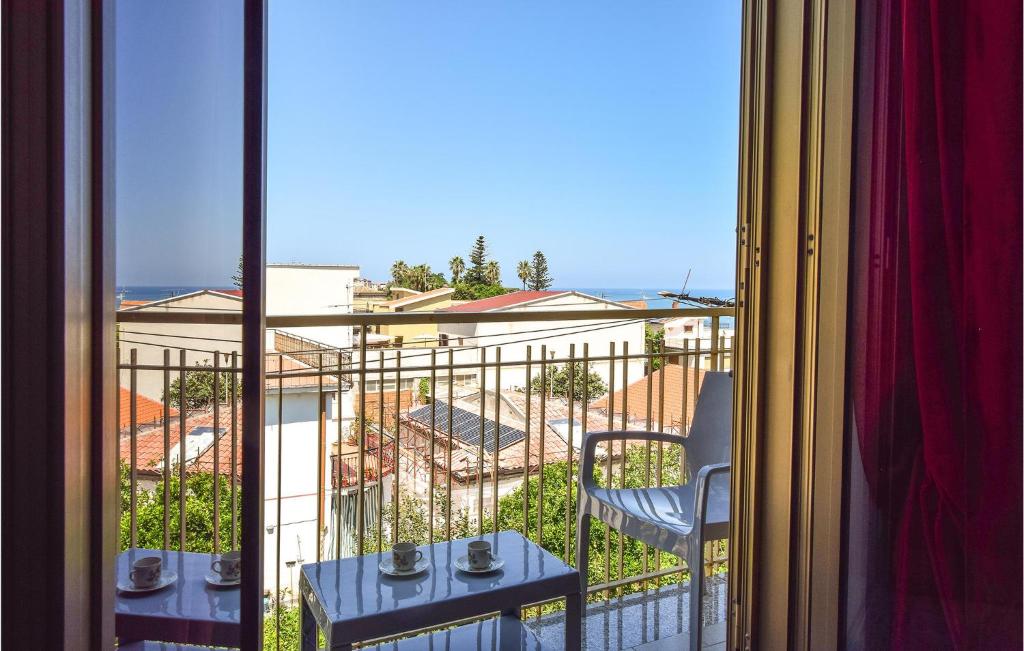 Habitación con balcón con mesa y ventana. en 2 Bedroom Lovely Apartment In Marina Di Caronia, en Caronia Marina