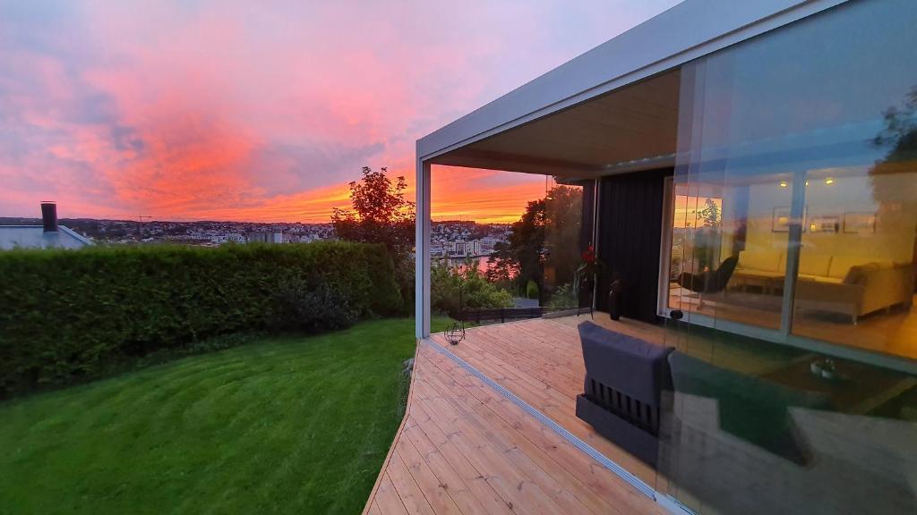 a house with a view of the sunset from a patio at Villa with great view in Sandnes