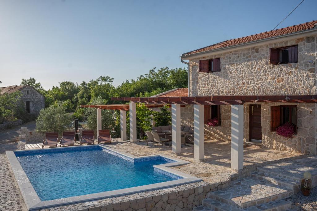 una villa con piscina frente a una casa en Villa Silente, en Ljubuški