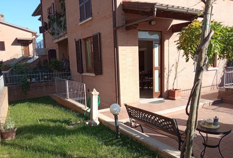 a bench sitting in the yard of a house at Appartamento Il Glicine in Montalcino