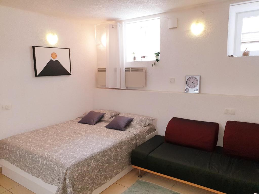 a small bedroom with a bed and a chair at Apartment Ognissanti 1 - free parking in Koper