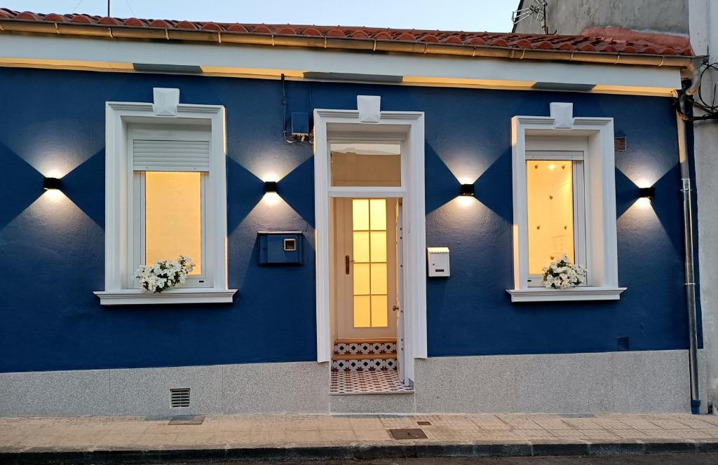 una casa azul con tres ventanas y una puerta en Casa Jardín, en Monforte de Lemos