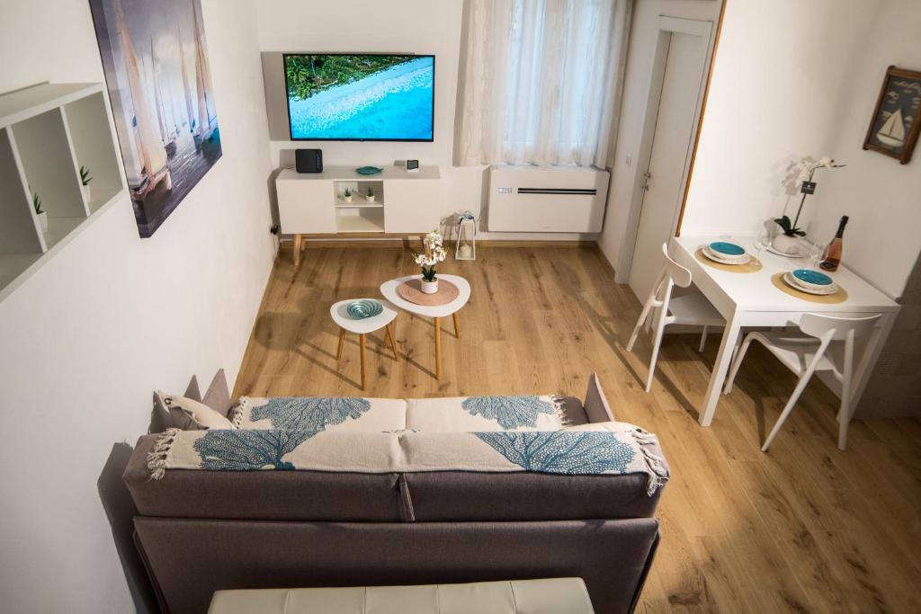 a living room with a couch and a table at Meraki House in Alghero