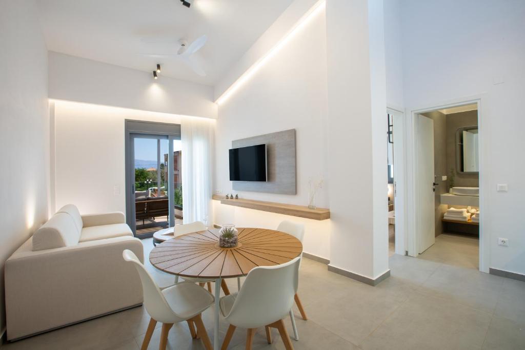 a living room with a couch and a table and chairs at Elianthi Luxury Apartments in Nikiana