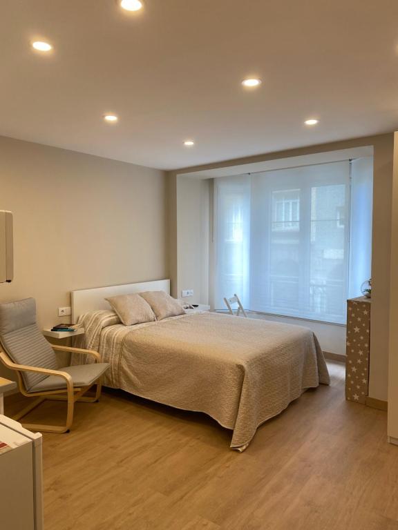 A bed or beds in a room at Alojamientos Muelle de Gijón