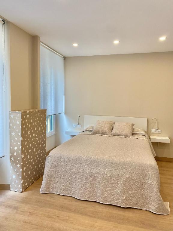 A bed or beds in a room at Alojamientos Muelle de Gijón