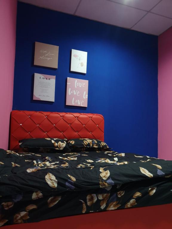 - une chambre avec un lit et un mur bleu dans l'établissement InapDesa Studio Kangar Perlis, à Kangar