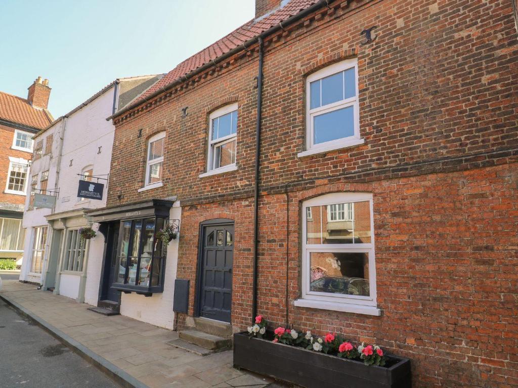 a brick building with flowers in a window at Audleby in Market Rasen