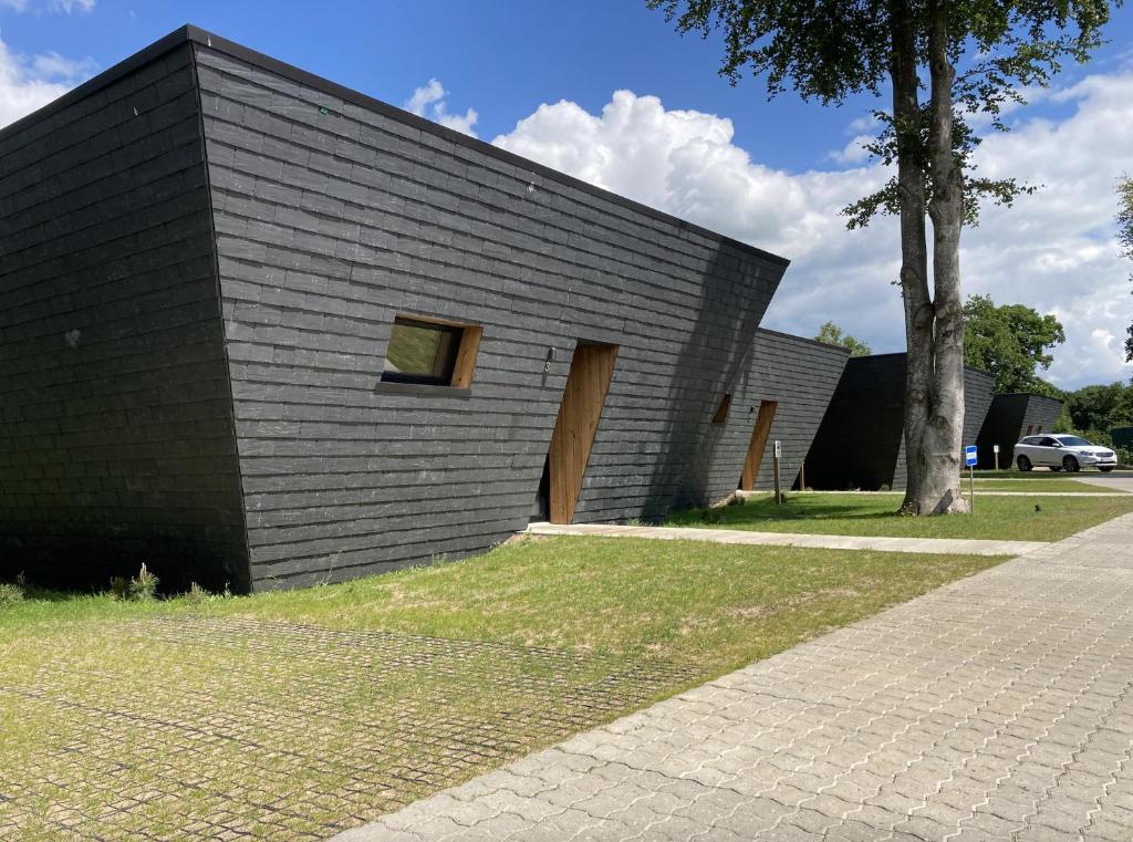 un edificio negro con una ventana en el costado en SØGAARDEN - Hotel & SøCamp, en Sunds