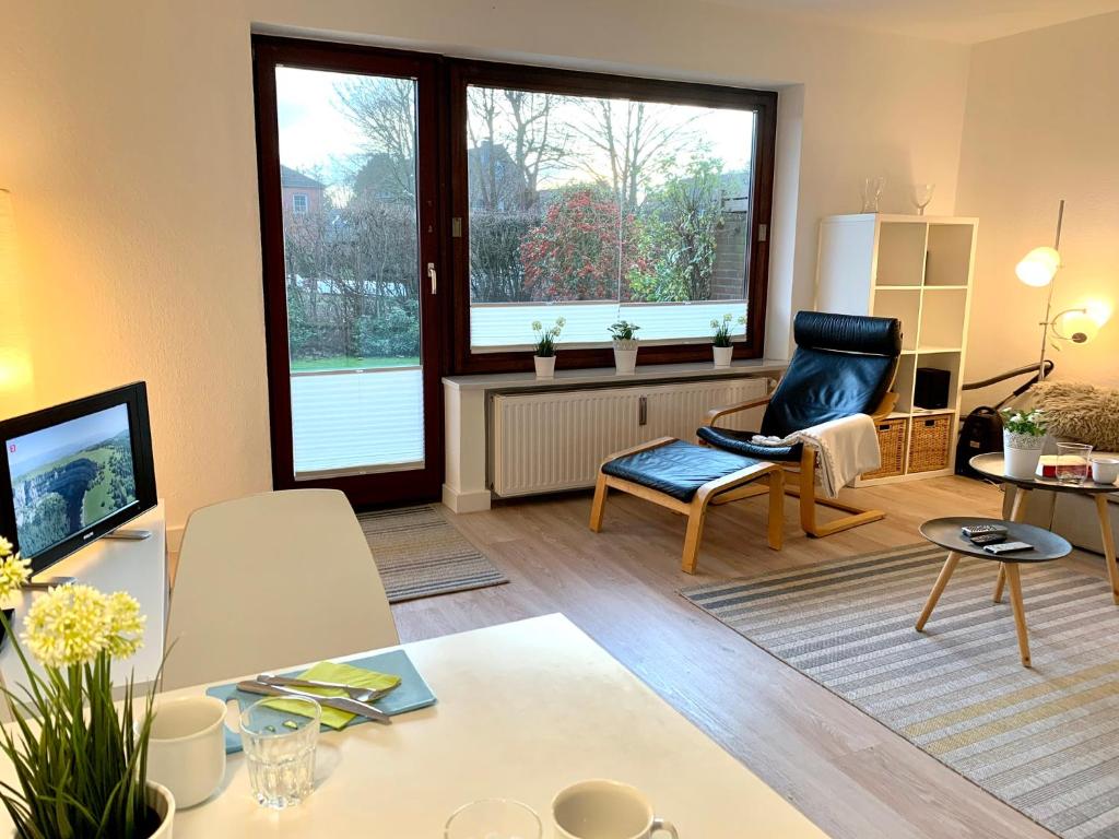 uma sala de estar com um sofá, uma cadeira e uma televisão em Ferienwohnung Seestern em Sankt Peter-Ording