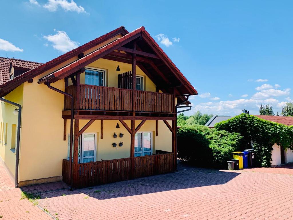 a house with a balcony on the side of it at Apartmány na Horce in Blata