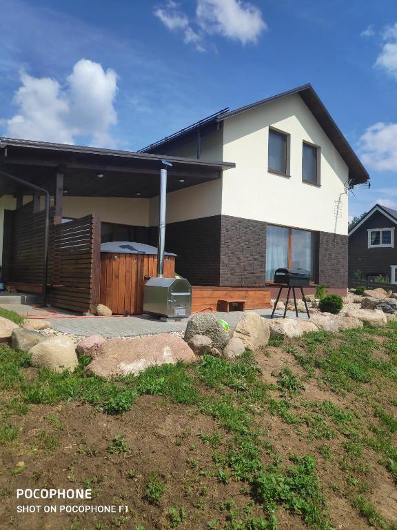 a house with rocks in front of it at Domo Vila in Druskininkai