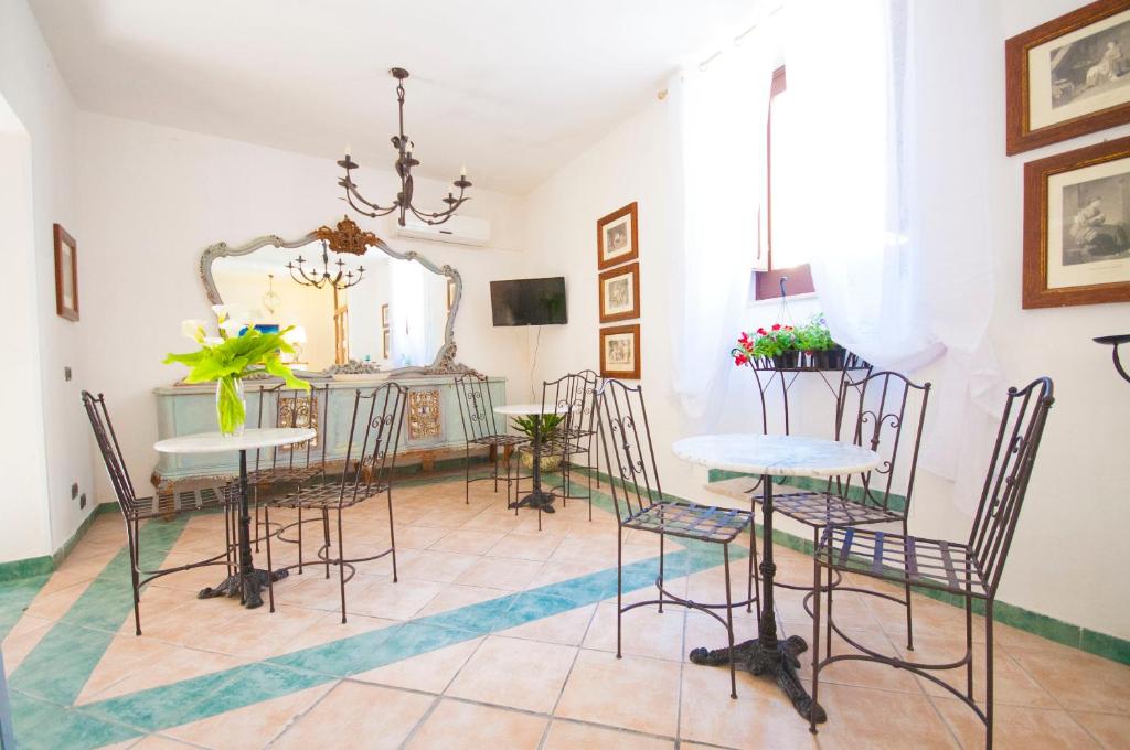 een eetkamer met stoelen, een tafel en een spiegel bij Albergo La Fontanella in Noto