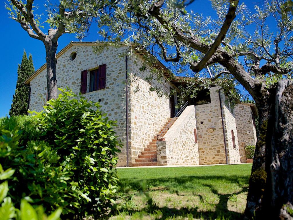 a large brick building with stairs in a yard at Agriturismo Le Colombe Assisi in Assisi