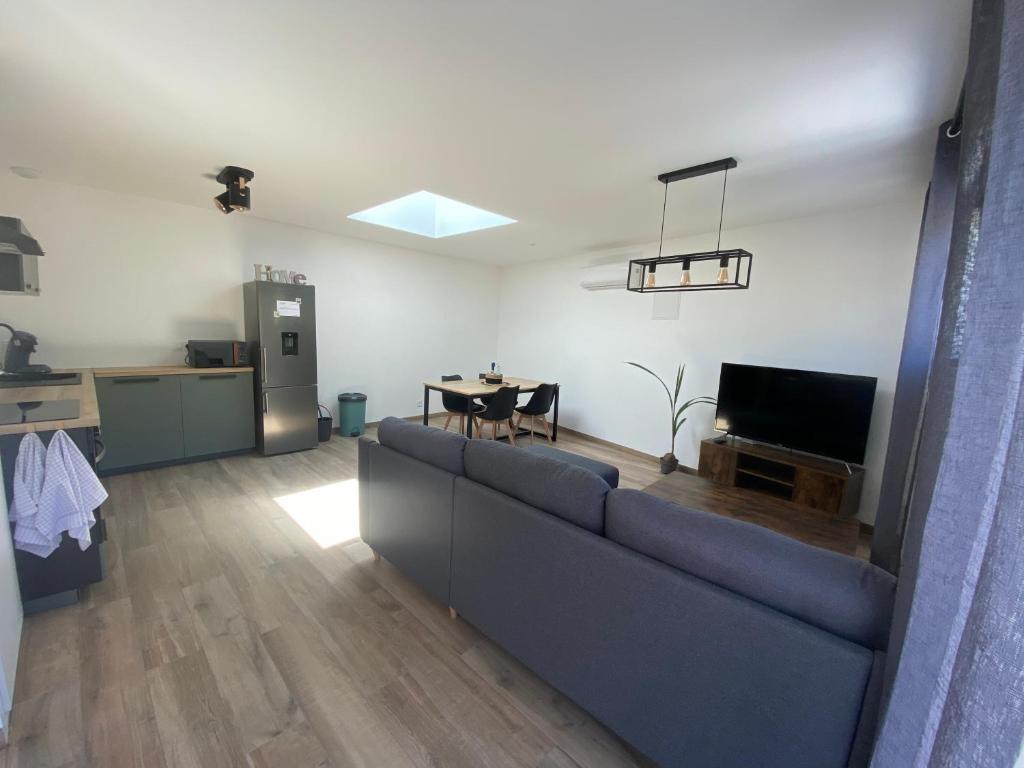 ein Wohnzimmer mit einem Sofa und einem Tisch in der Unterkunft Maison vacance in Sainte-Soulle