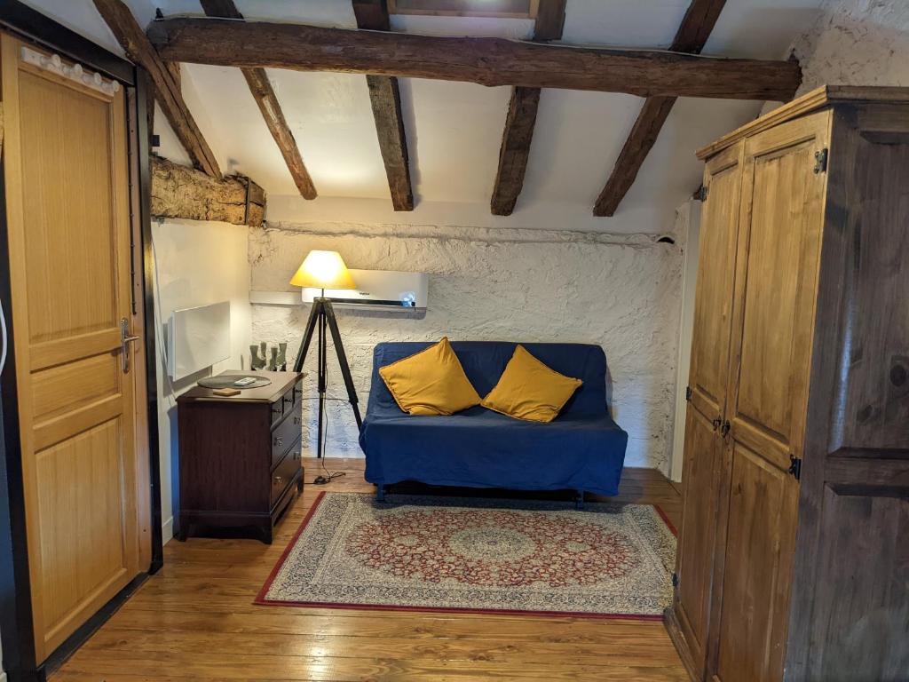 a blue couch with two yellow pillows in a room at Gîte L'Ancienne Charcuterie in Buzet-sur-Baïse