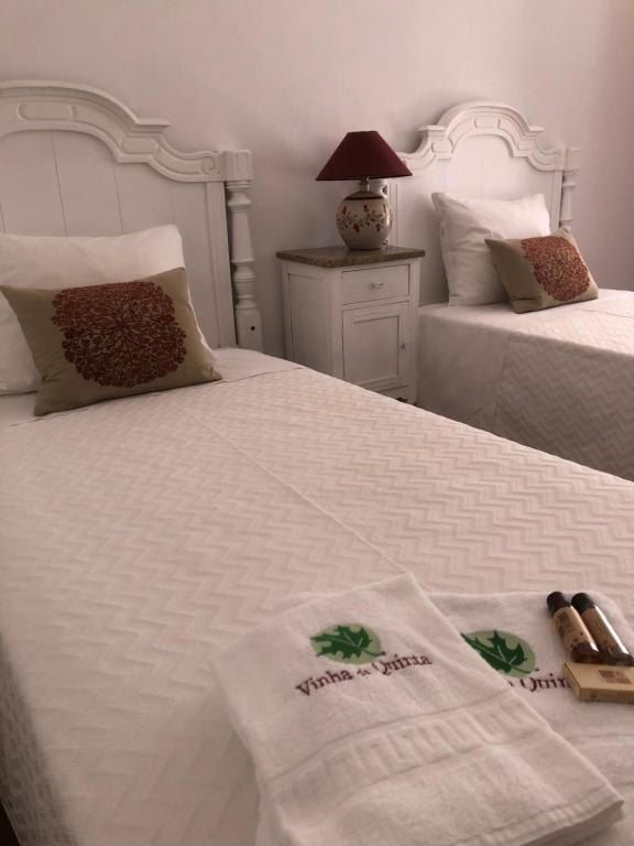 a bedroom with two beds with towels on them at Vinha da Quinta in Sintra