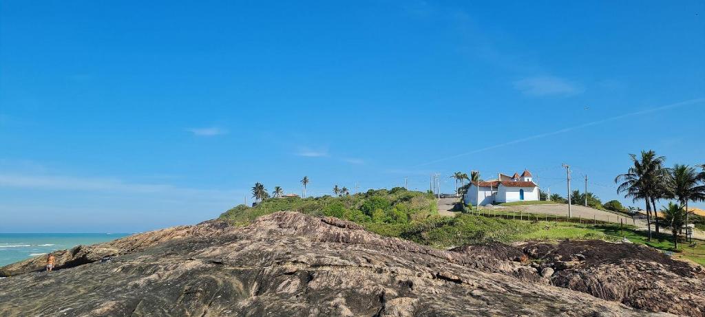 a house on top of a hill next to the ocean at Cobertura Duplex Vista Mar Meaipe in Guarapari