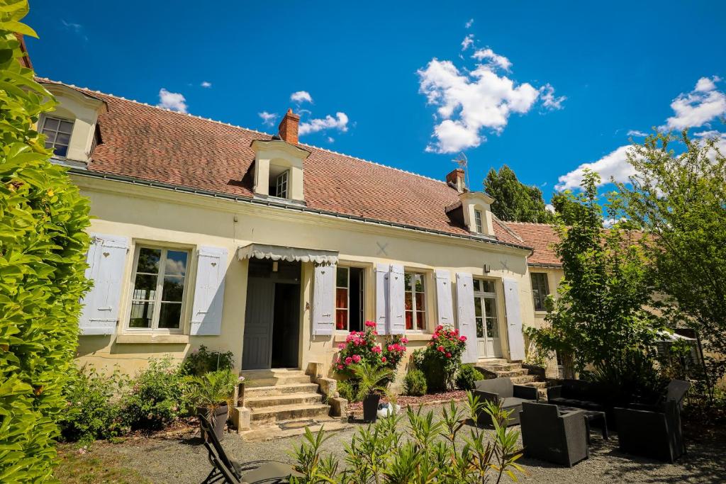 uma casa branca com flores no jardim da frente em Le Grand Presbytère de Beaulieu em Beaulieu-lès-Loches